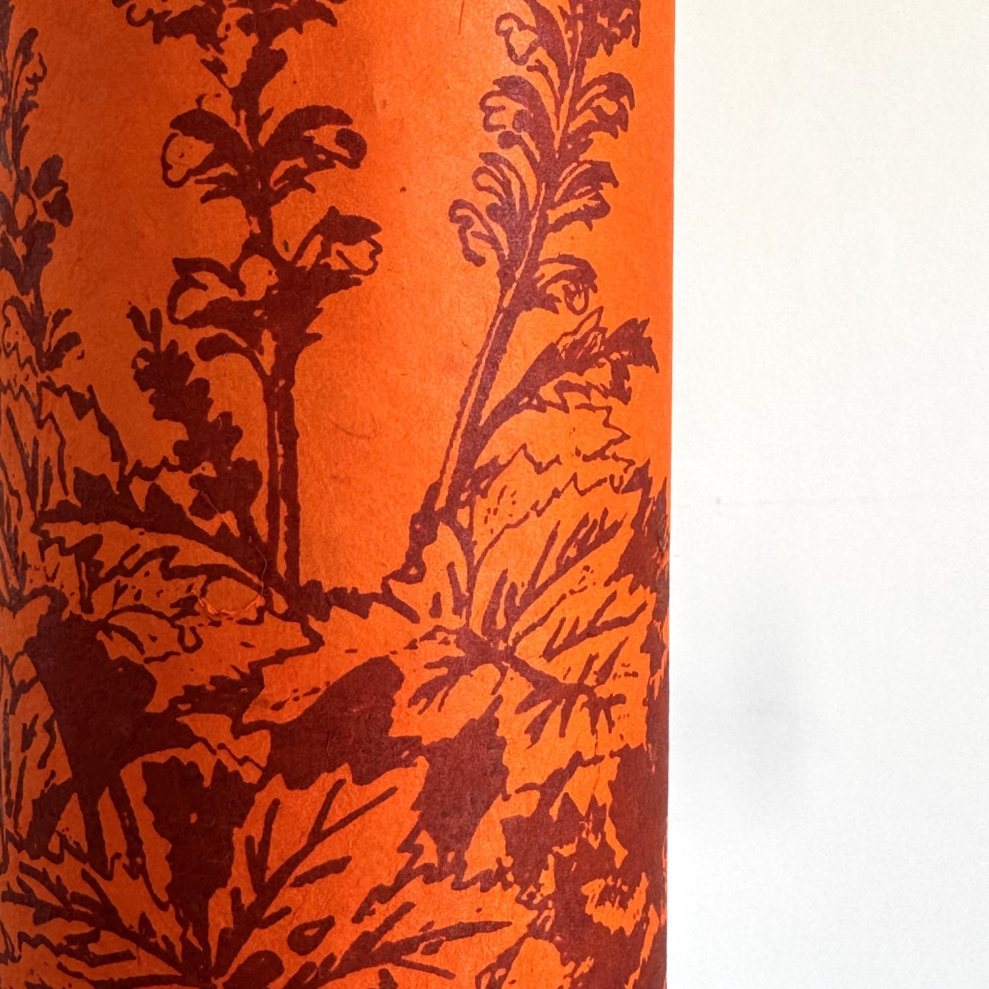 Nepalese handmade decorative lokta paper sheet with a Toile de Jouy style pattern of an agapanthus flower in burgundy screen printed on an orange lokta paper