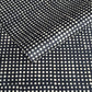 a sheet of black batik dyed Nepalese lokta paper with repeat design of white dots.  Pictured lightly folded
