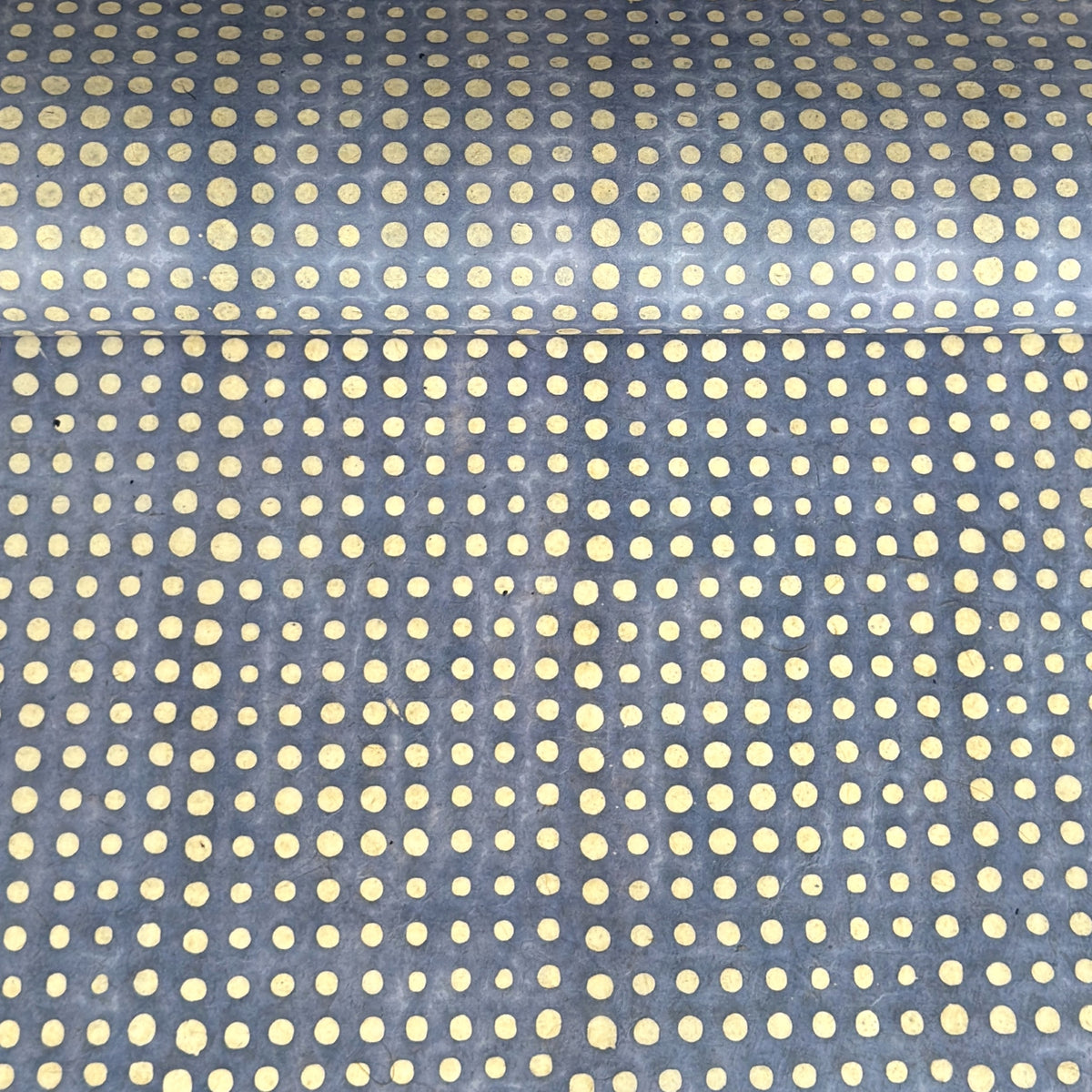 a sheet of Nepalese batik lokta paper in sky blue with a repeat white dot pattern. 