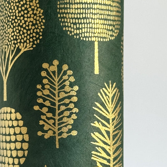Nepalese handmade decorative lokta paper sheet with gold trees screen printed on a dark green lokta paper.