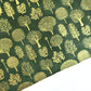 Nepalese handmade decorative lokta paper sheet with gold trees screen printed on a dark green lokta paper. 