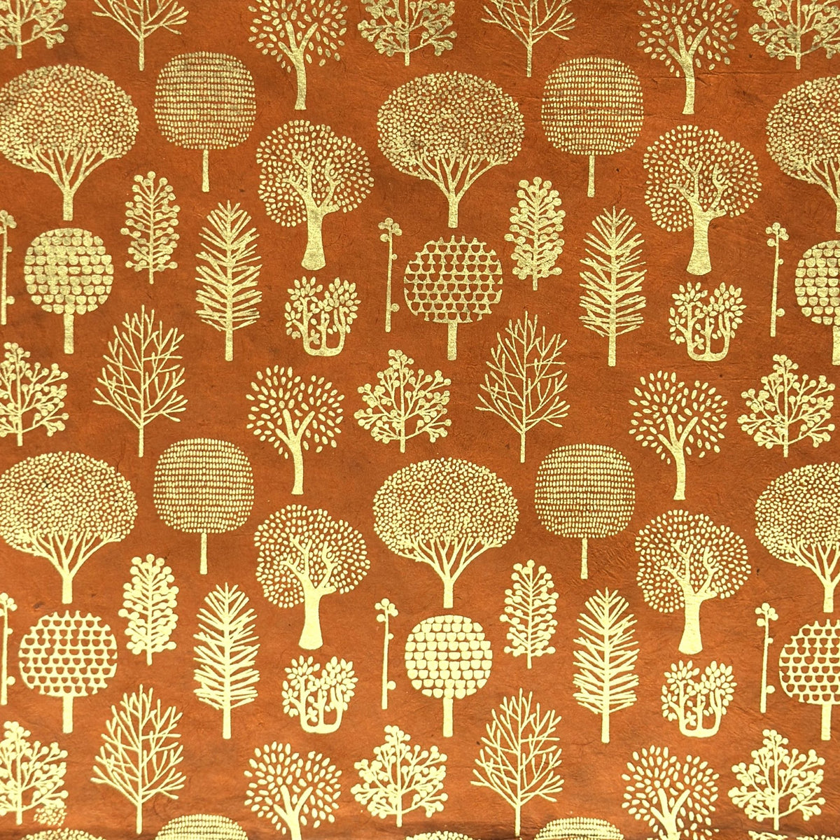 a sheet of screen printed Nepalese lokta paper in terracotta brown with gold trees.  