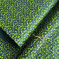 a sheet of lokta paper with a green abstract gingko design on dark green paper