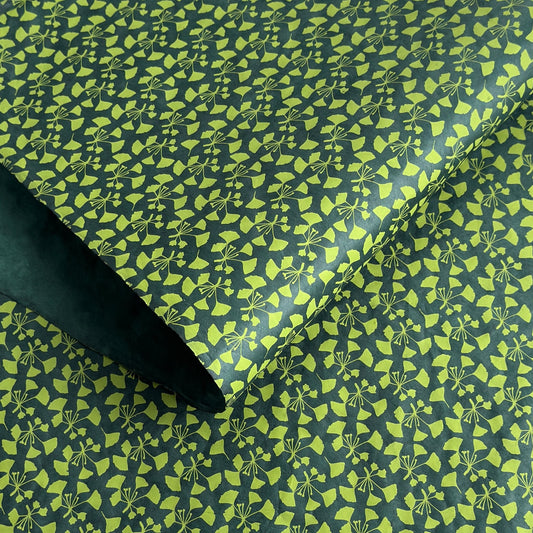 a sheet of lokta paper with a green abstract gingko design on dark green paper