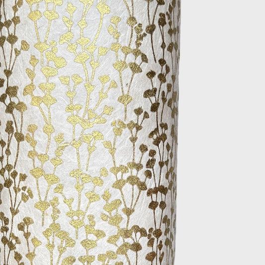 nepalese hand printed lokta paper with a small gold abstract gingko design on white lokta paper. close up