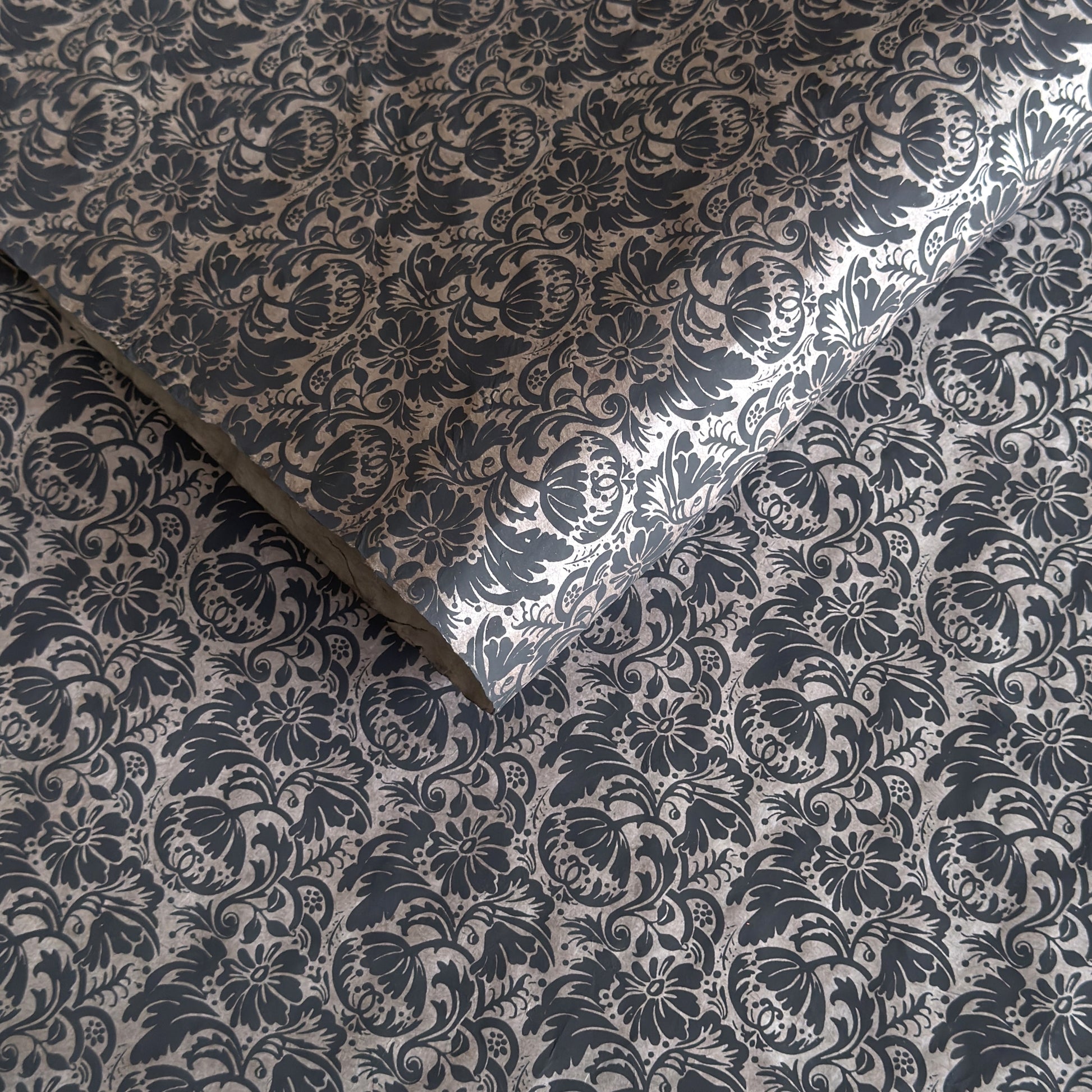 Nepalese handmade decorative lokta paper sheet with a black floral pattern screen printed on a dark taupe lokta paper.