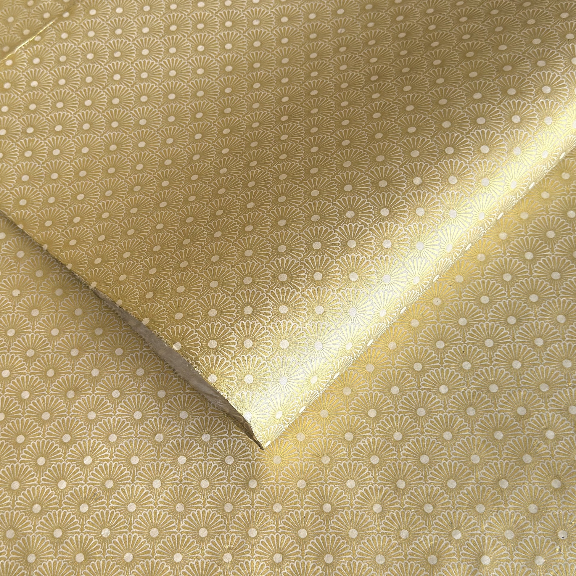 Nepalese handmade decorative lokta paper sheet with a gold metallic repeat floral pattern screen printed on an ivory lokta paper.