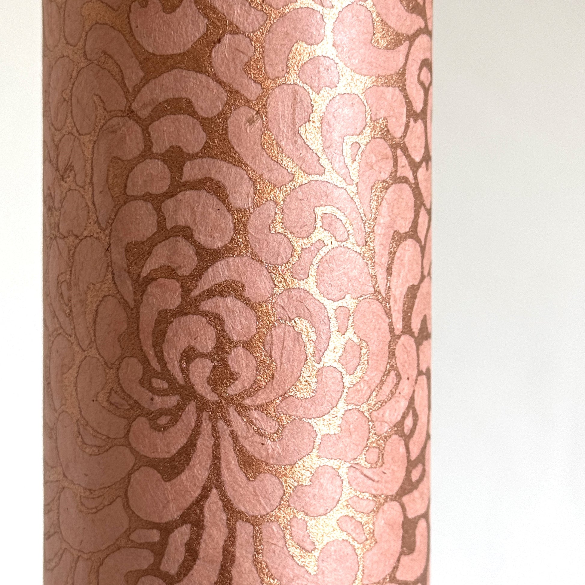 Nepalese handmade decorative lokta paper sheet with a metallic copper floral print screen printed on a blush pink lokta paper. close-up