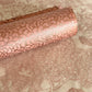 Nepalese handmade decorative lokta paper sheet with a metallic copper floral print screen printed on a blush pink lokta paper. Pictured rolled