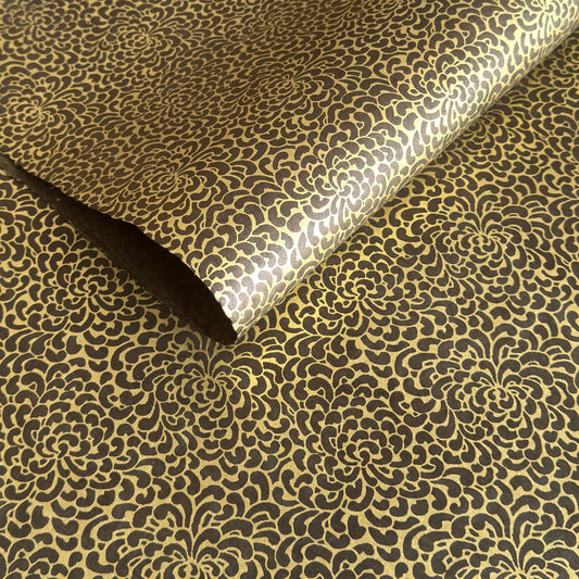 Nepalese handmade decorative lokta paper sheet with a gold screen printed floral design on a brown dyed lokta paper.