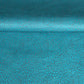 a sheet of Nepalese lokta paper screen printed with a repeat floral pattern in dark grey/blue on a bright teal lokta paper