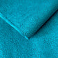 a sheet of Nepalese lokta paper screen printed with a repeat floral pattern in dark grey/blue on a bright teal lokta paper