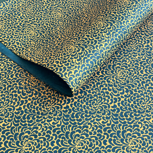 Nepalese handmade decorative lokta paper sheet with a saffron floral print screen printed on a teal lokta paper. 