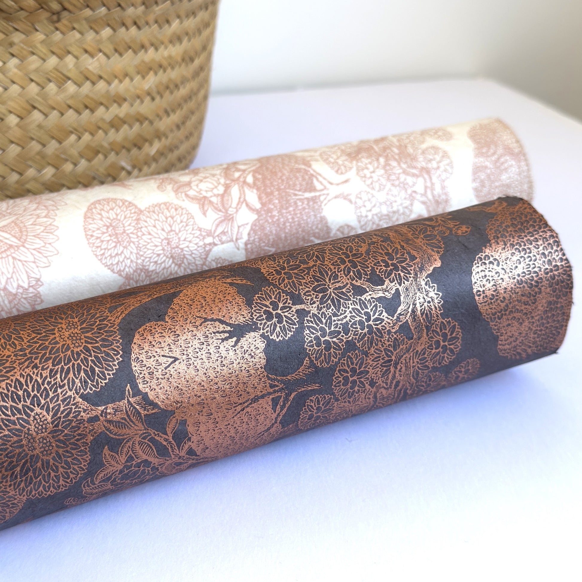 Nepalese handmade decorative lokta paper sheet with a detailed design of trees and flowers in copper screen printed on a dusty violet lokta paper. Rolled