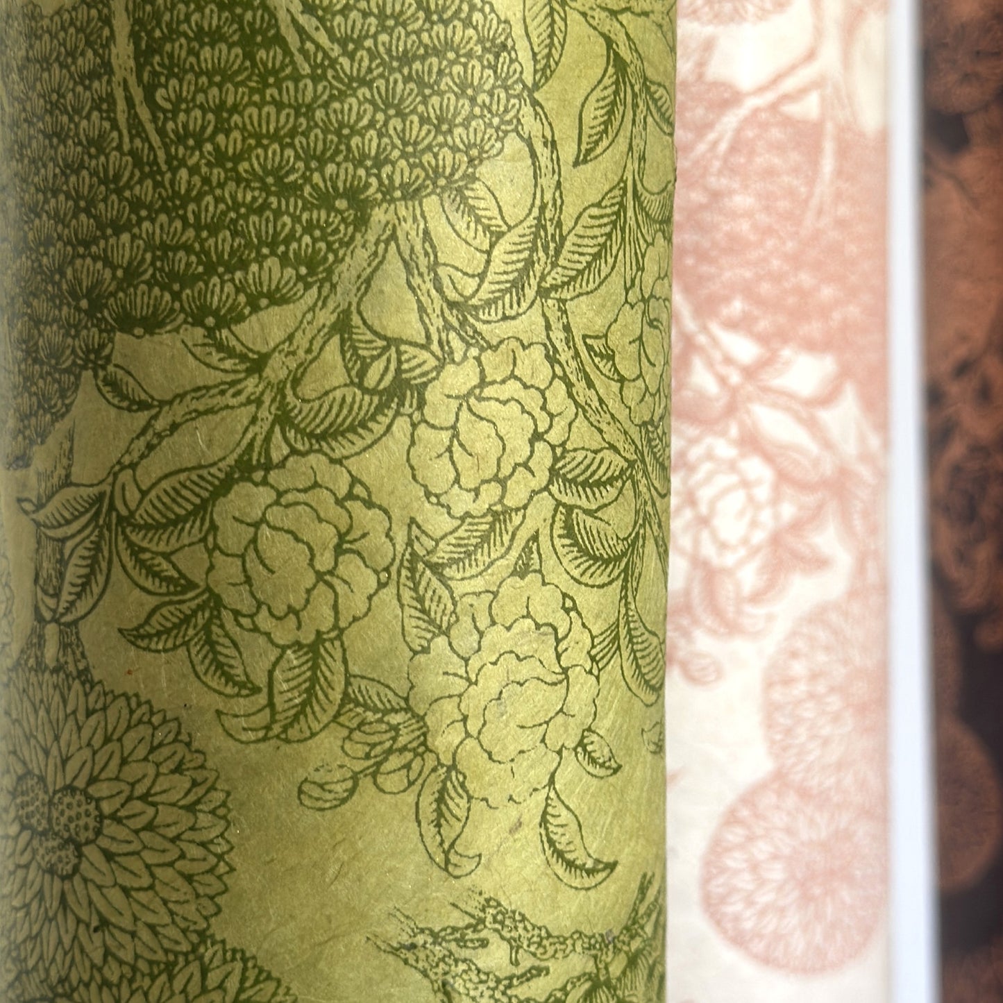 Nepalese handmade decorative lokta paper sheet with a detailed design of trees and flowers in dark green screen printed on a green lokta paper.