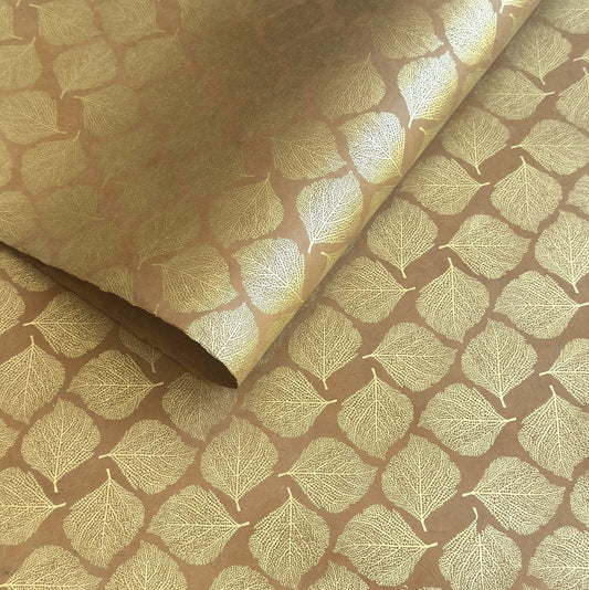 Nepalese handmade decorative lokta paper sheet with a gold metallic leaf pattern screen printed on a tan lokta paper.