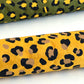 Nepalese handmade decorative lokta paper sheet with an animal print design in two colours, tan and black, screen printed on a yellow lokta paper. Rolled