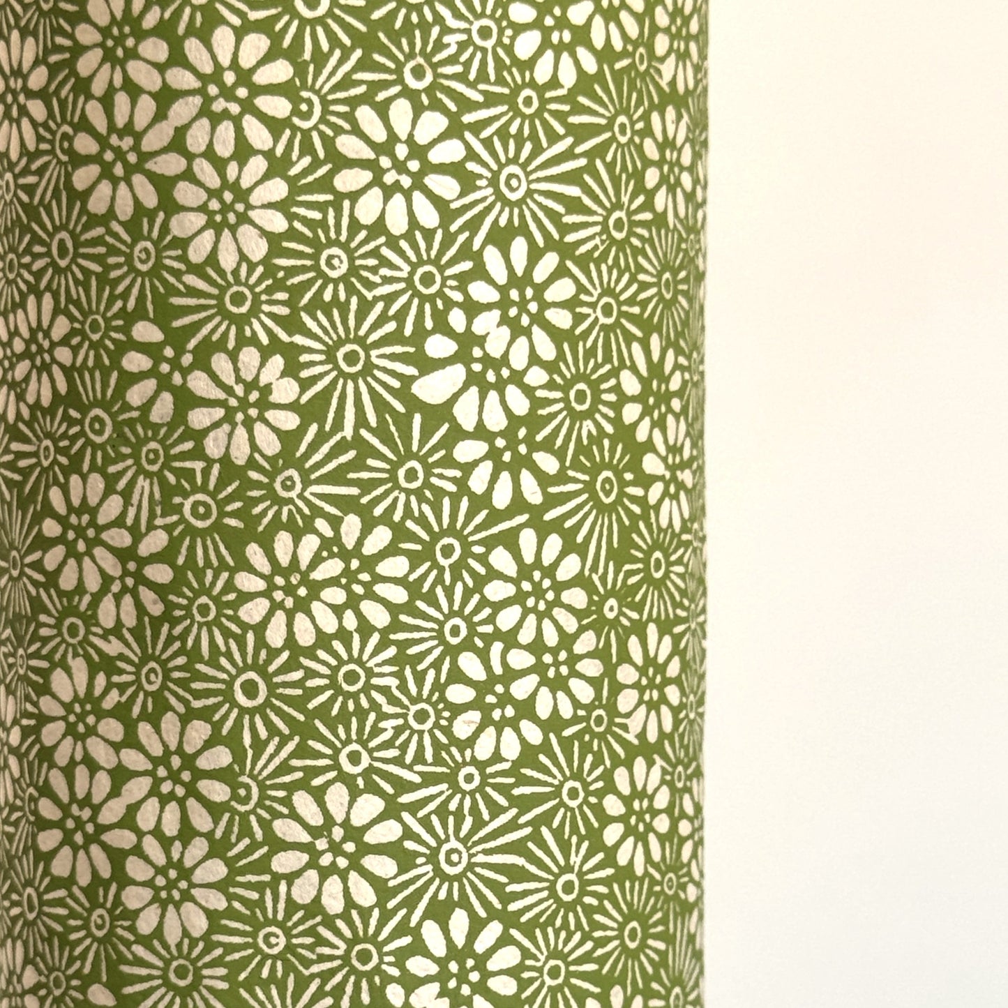 Nepalese handmade decorative lokta paper sheet with a white ditsy floral design screen printed on a green lokta paper.