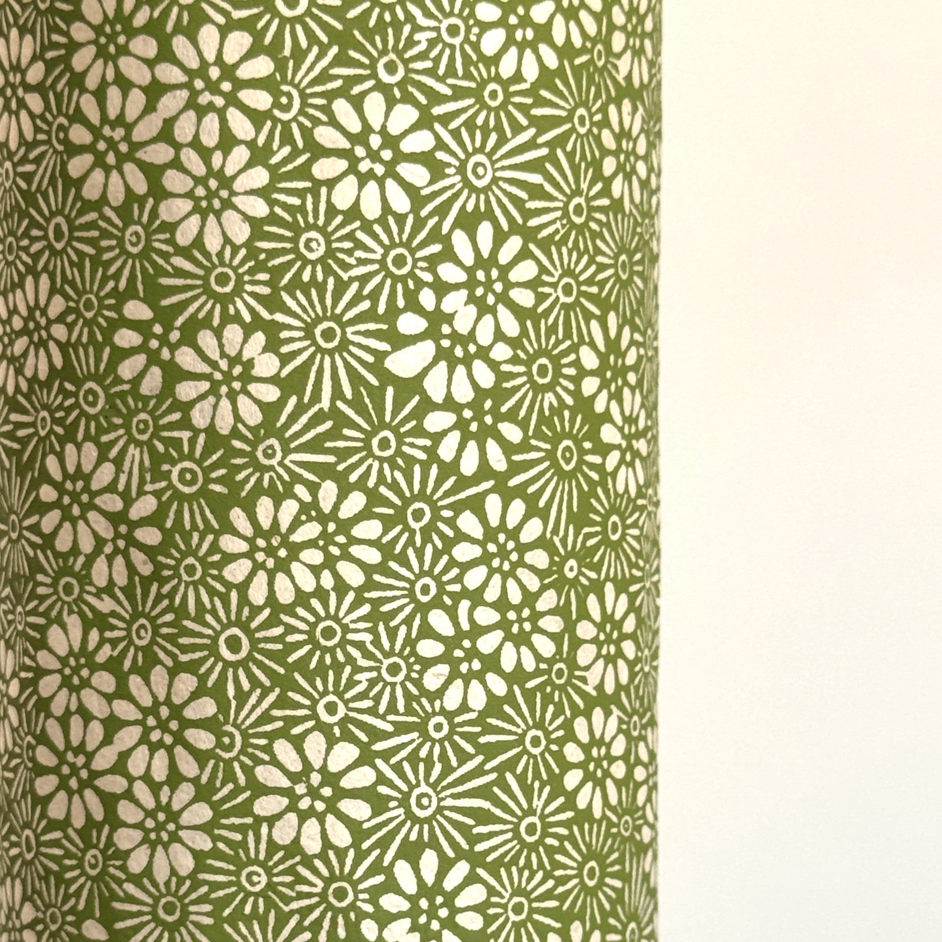 Nepalese handmade decorative lokta paper sheet with a white ditsy floral design screen printed on a green lokta paper.