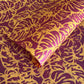 Nepalese handmade decorative lokta paper sheet with a leaf pattern in burgundy red and yellow.  Batik dyed using carved wooden blocks.