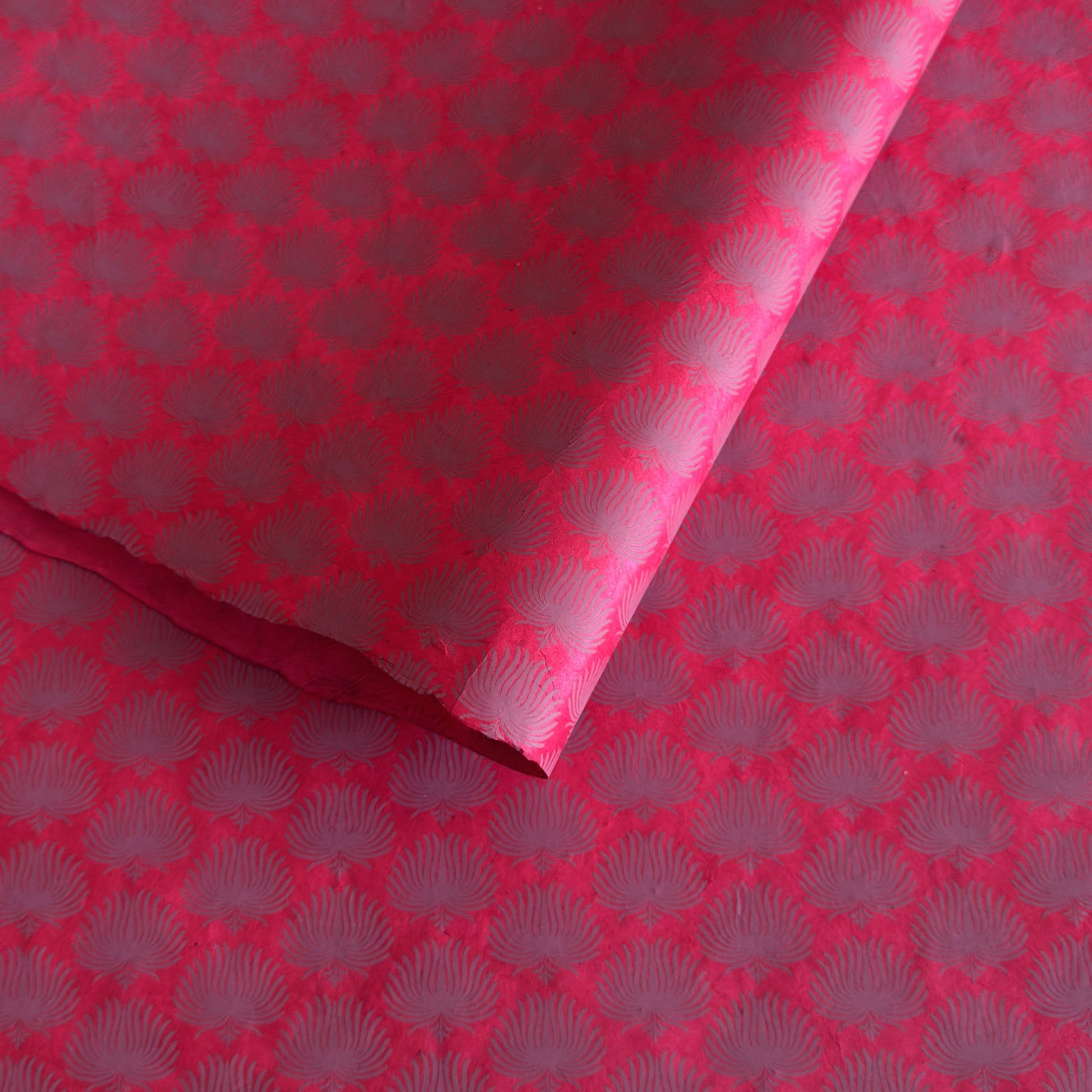 Nepalese handmade decorative lokta paper sheet with a lilac palm leaf design screen printed on a fuchsia pink lokta paper.