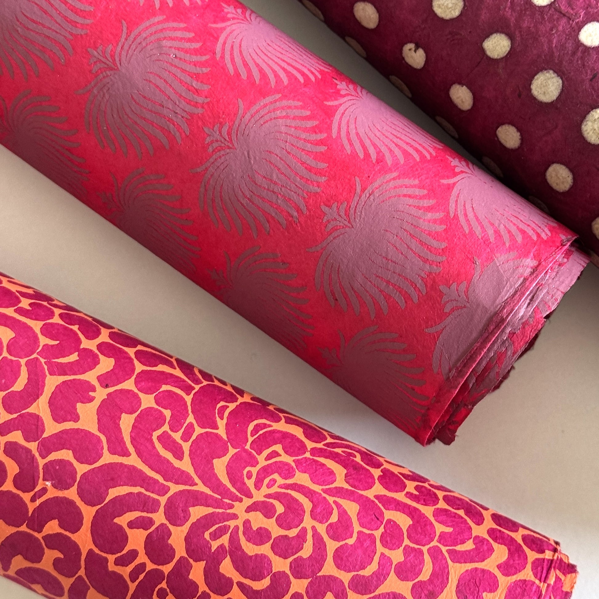 Nepalese handmade decorative lokta paper sheet with a lilac palm leaf design screen printed on a fuchsia pink lokta paper.