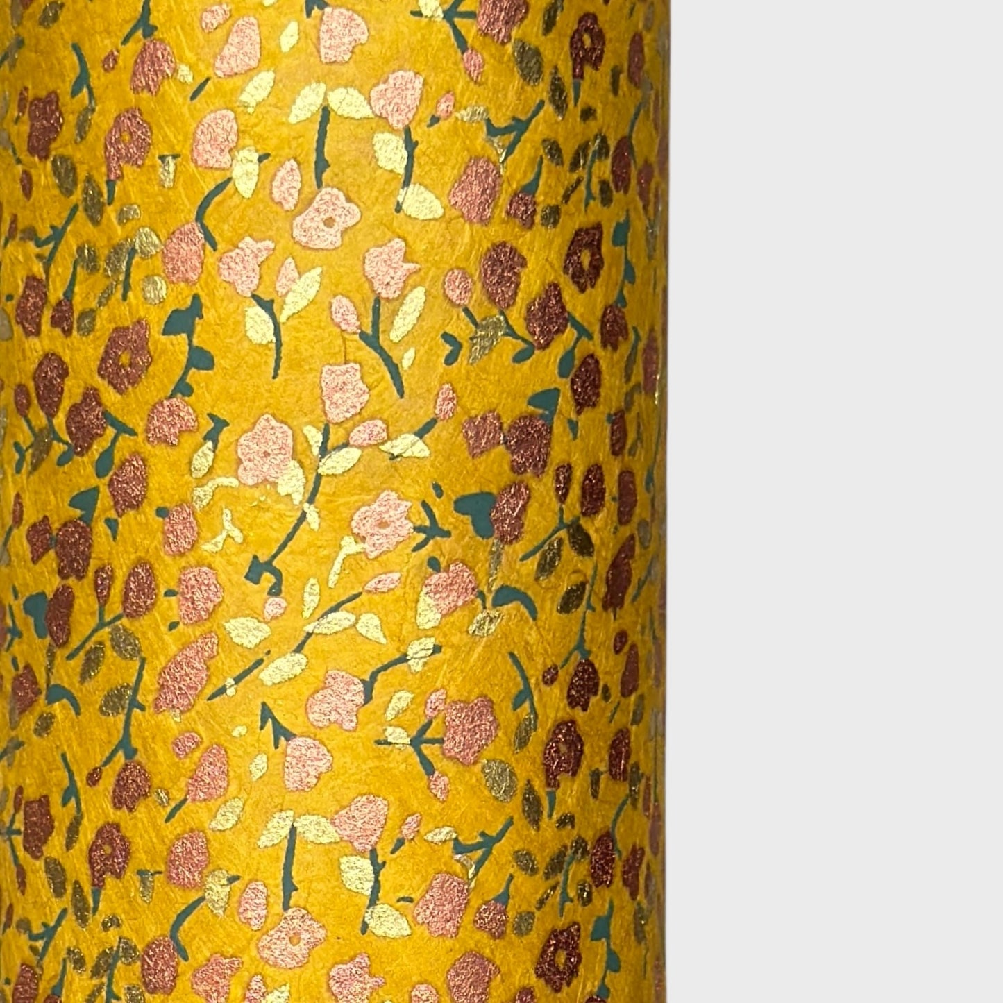 A delicate floral pattern in gold, blush and green screen-printed by hand on mustard yellow lokta paper.
