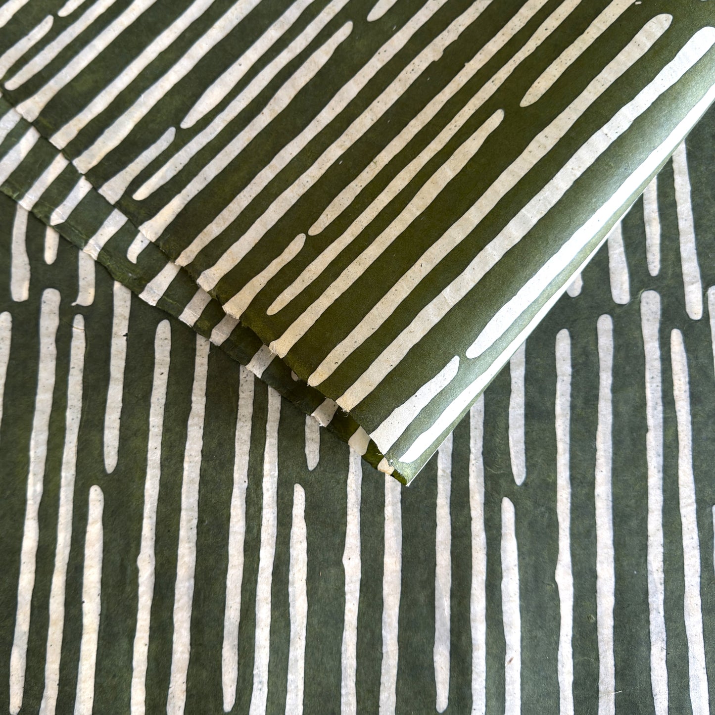 Nepalese handmade decorative lokta paper sheet with a stripe pattern in mossy and white.  Batik dyed using carved wooden blocks. 