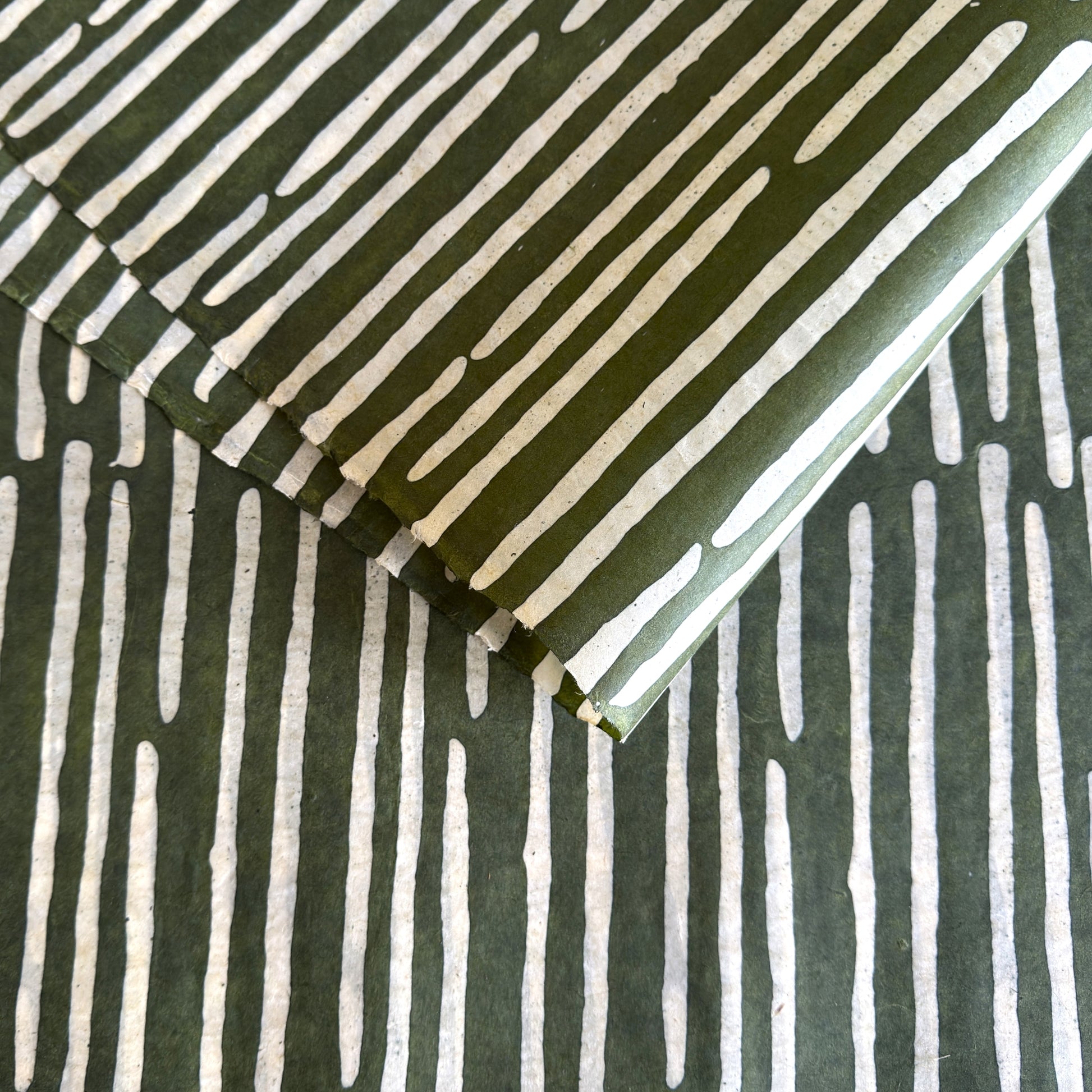 Nepalese handmade decorative lokta paper sheet with a stripe pattern in mossy and white.  Batik dyed using carved wooden blocks. 