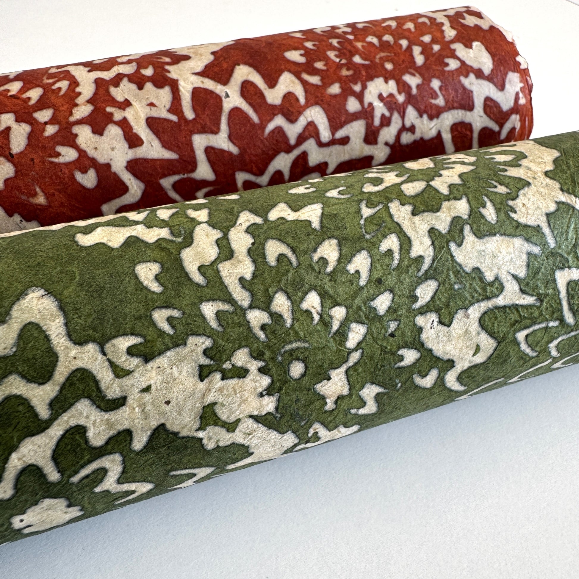 Nepalese handmade decorative lokta paper sheet with a floral pattern in green and cream.  Batik dyed using carved wooden blocks. Rolled