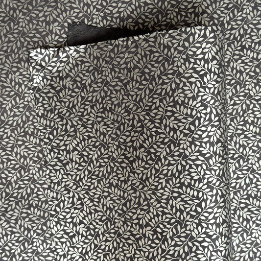 a sheet of screen printed Nepalese lokta paper with a small repeat silver leaf design on slate grey lokta paper