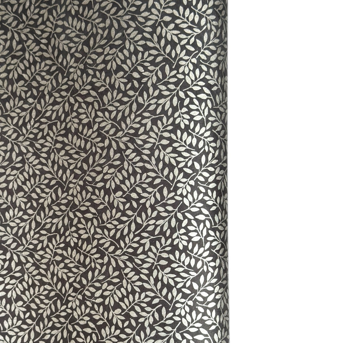 a sheet of screen printed Nepalese lokta paper with a small repeat silver leaf design on slate grey lokta paper