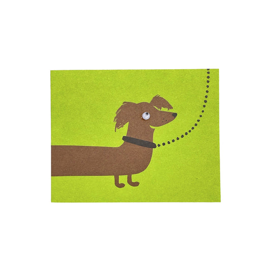 Small greetings card of a drawing of a brown sausage dog on a lead with lime green backdrop by Lisa Jones Studio