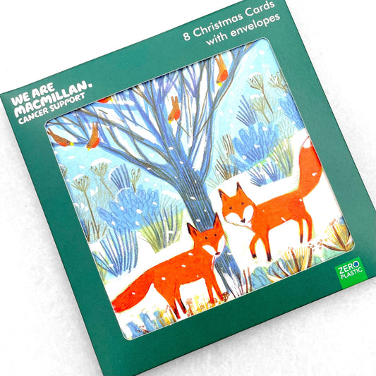 greetings card showing two bright orange foxes under a tree with robins in a snowy landscape