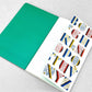 Small stitched notebook with a colourful alphabet cover design in red, blue and yellow on white background