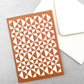 greetings card with abstract triangular pattern in white and brick red by Ola Studio, with white envelope