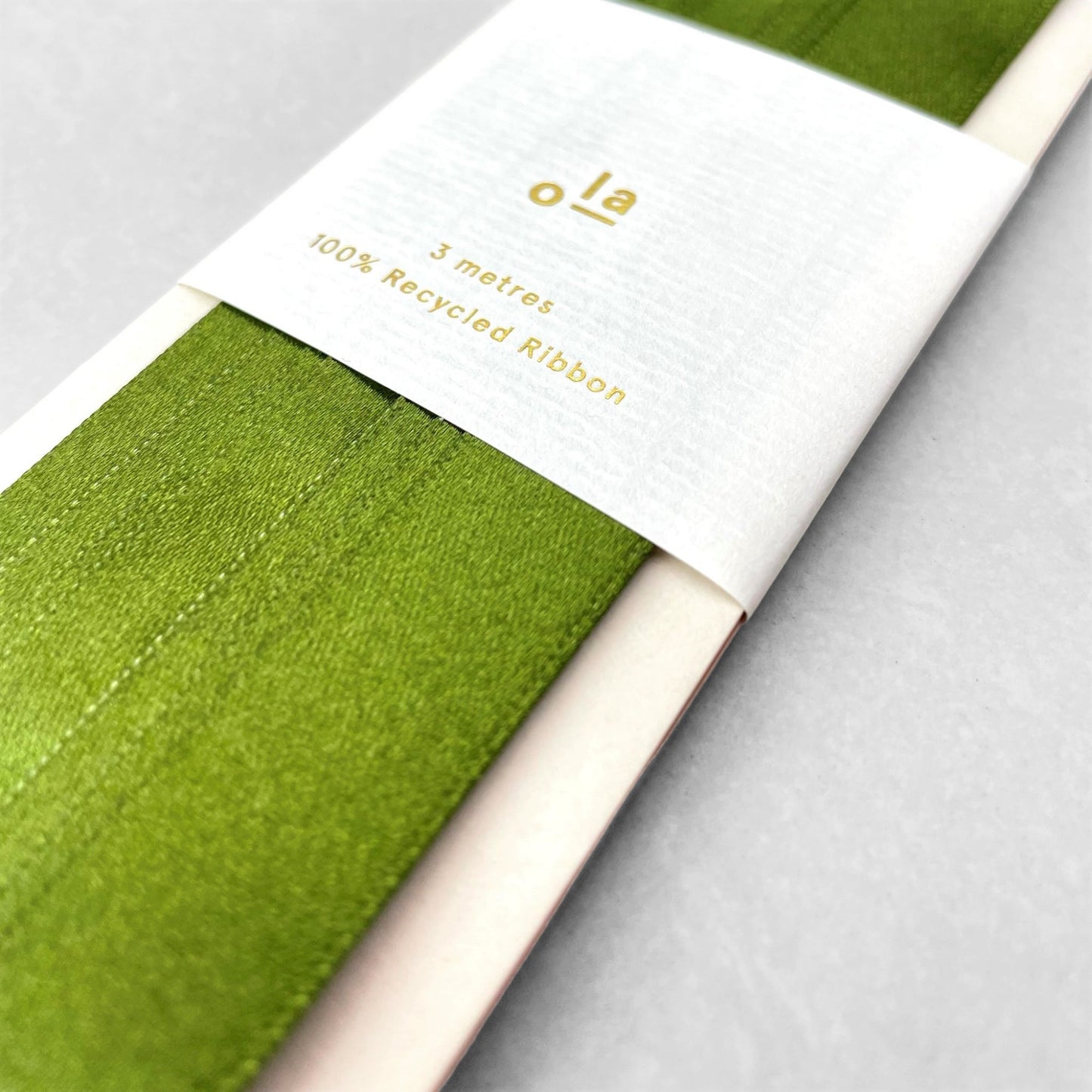 Luxury olive green satin ribbon on a rectangular board by Ola Studio