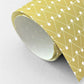 wrapping paper with abstract triangle and dot pattern in mustard and white by Ola Studio