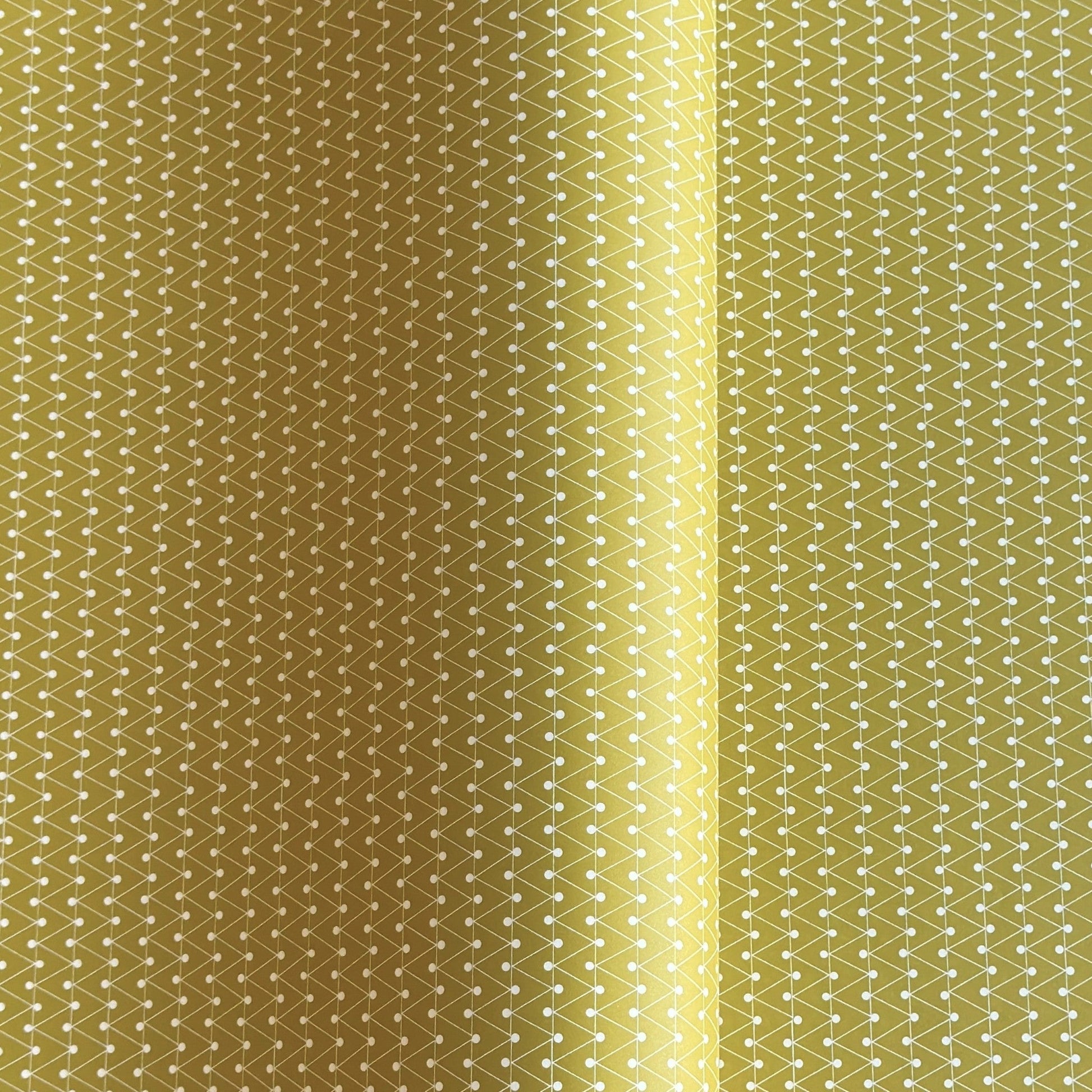 wrapping paper with abstract triangle and dot pattern in mustard and white by Ola Studio
