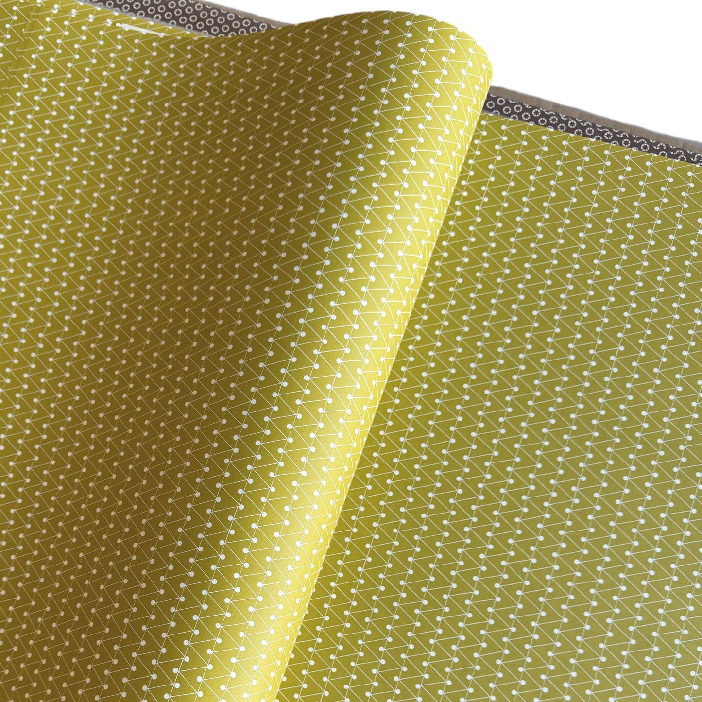 wrapping paper with abstract triangle and dot pattern in mustard and white by Ola Studio