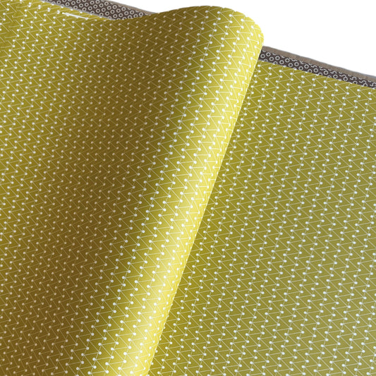wrapping paper with abstract triangle and dot pattern in mustard and white by Ola Studio
