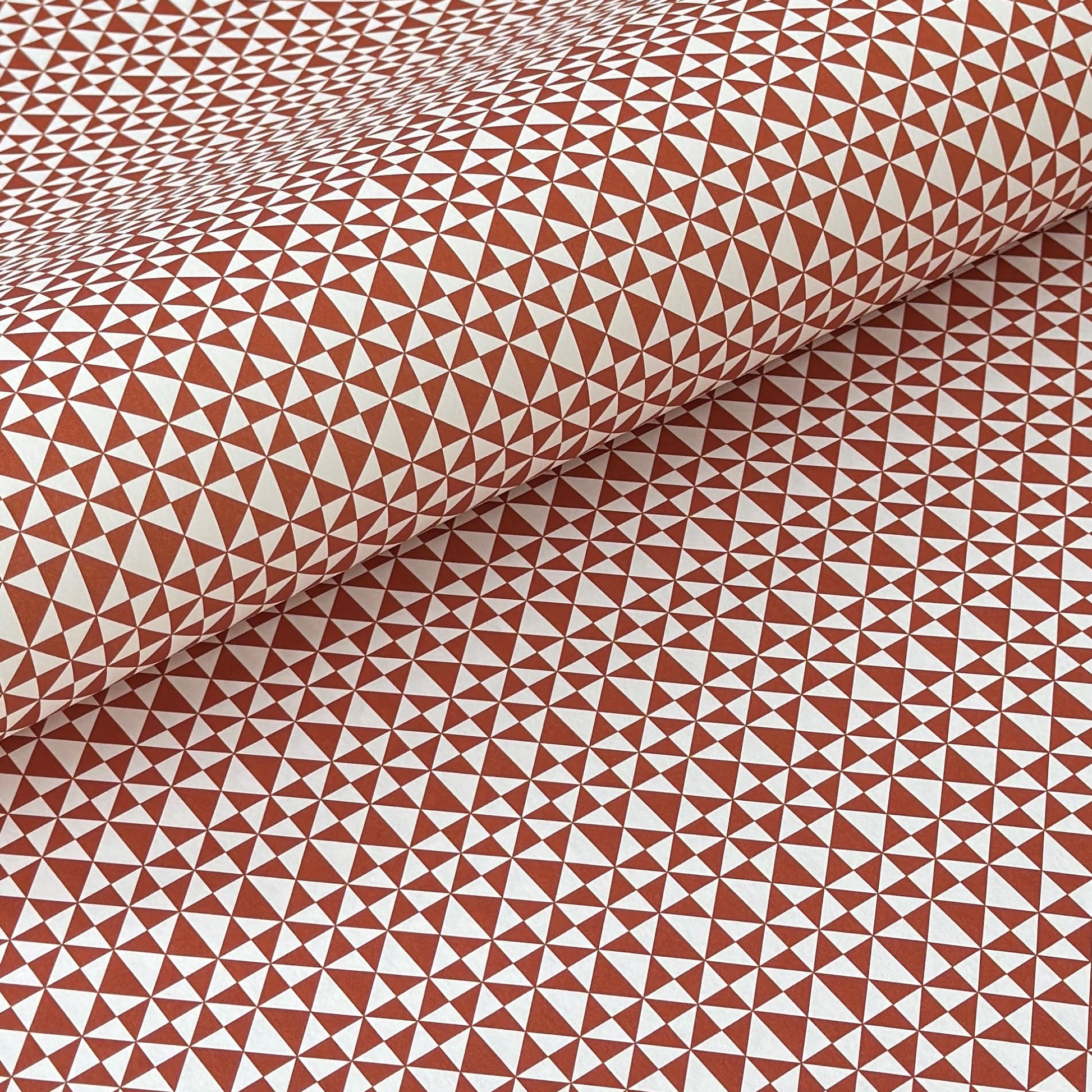 wrapping paper sheet by Ola Studio with a geometric triangle pattern in brick red on white