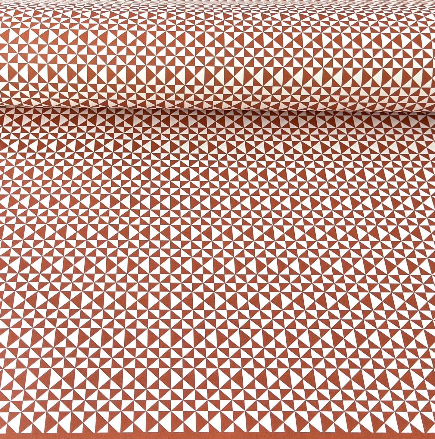wrapping paper sheet by Ola Studio with a geometric triangle pattern in brick red on white