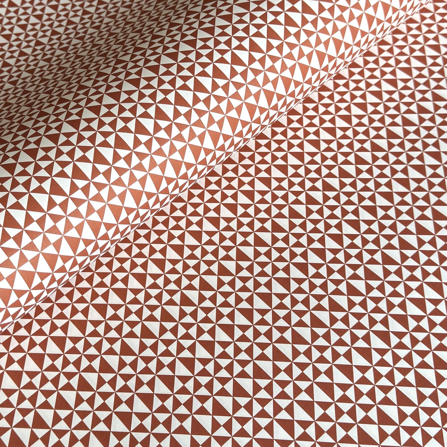 wrapping paper sheet by Ola Studio with a geometric triangle pattern in brick red on white
