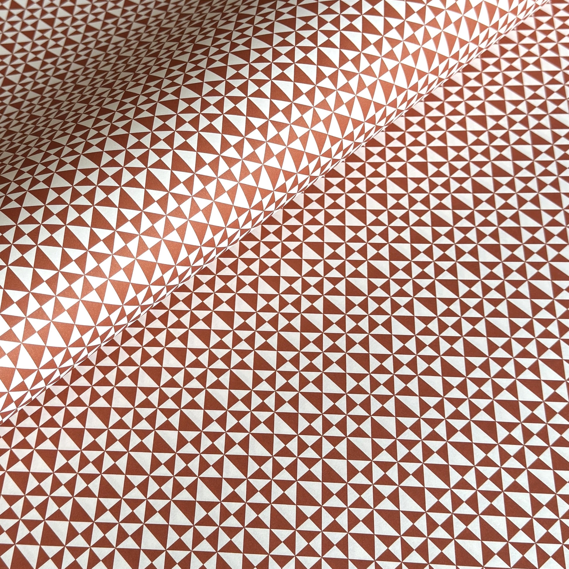 wrapping paper sheet by Ola Studio with a geometric triangle pattern in brick red on white