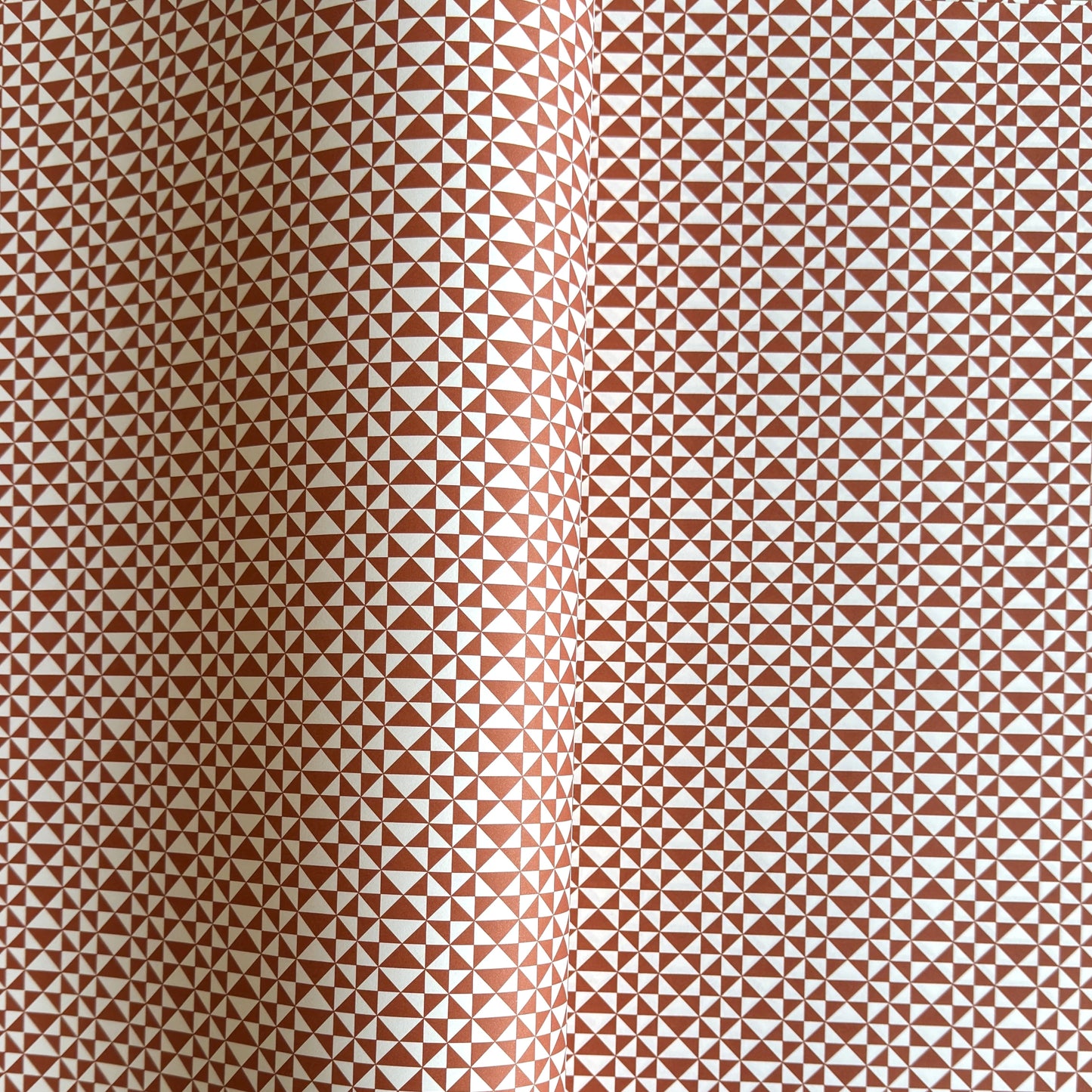 wrapping paper sheet by Ola Studio with a geometric triangle pattern in brick red on white