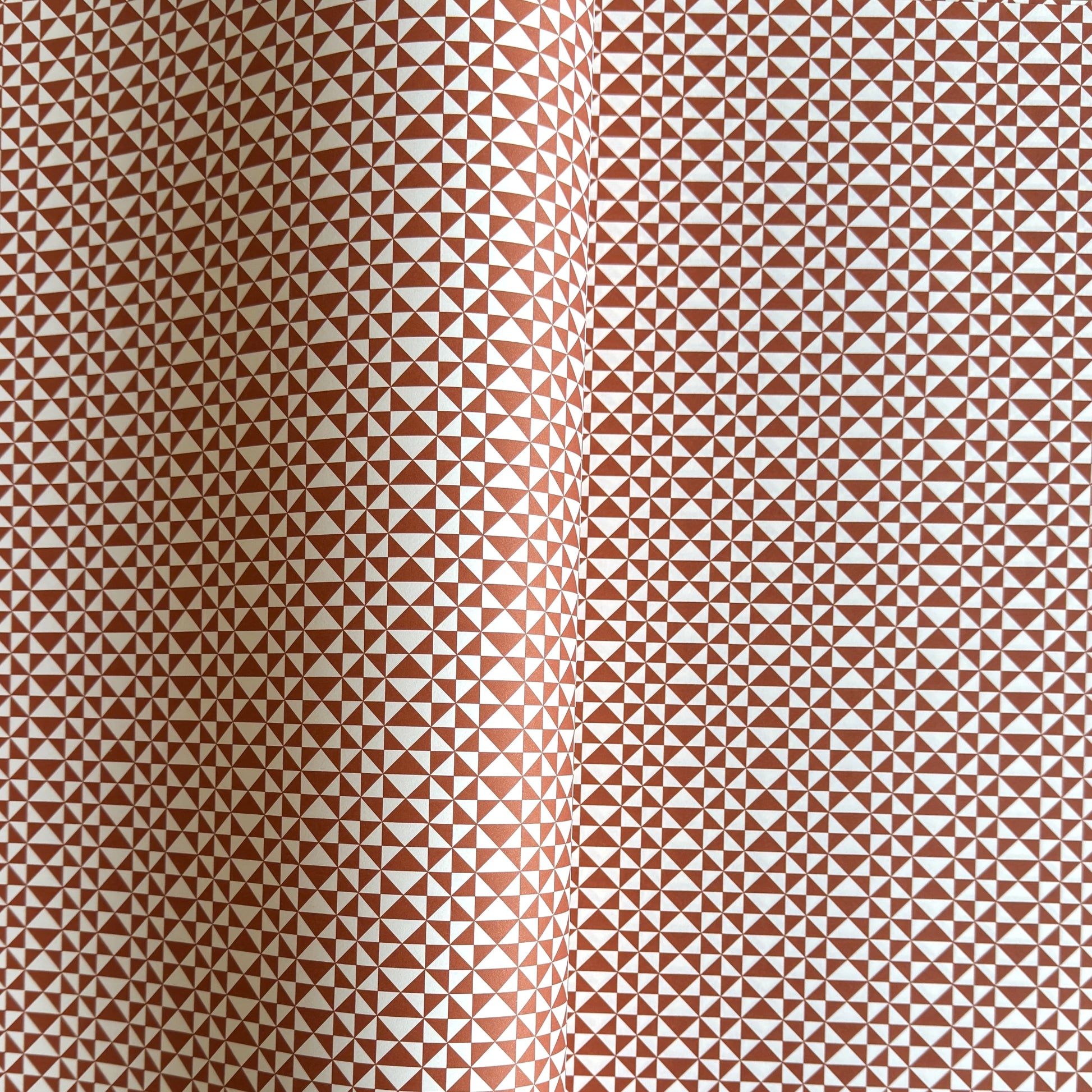 wrapping paper sheet by Ola Studio with a geometric triangle pattern in brick red on white
