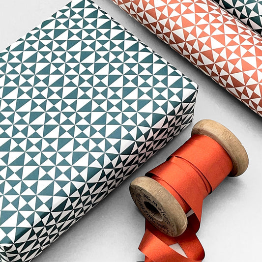 wrapping paper with an abstract triangle pattern in deep teal and white by Ola Studio