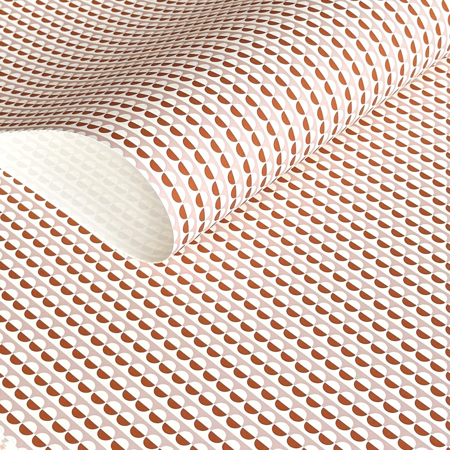 wrapping paper with an abstract circle pattern in orange and pale pink by Ola Studio
