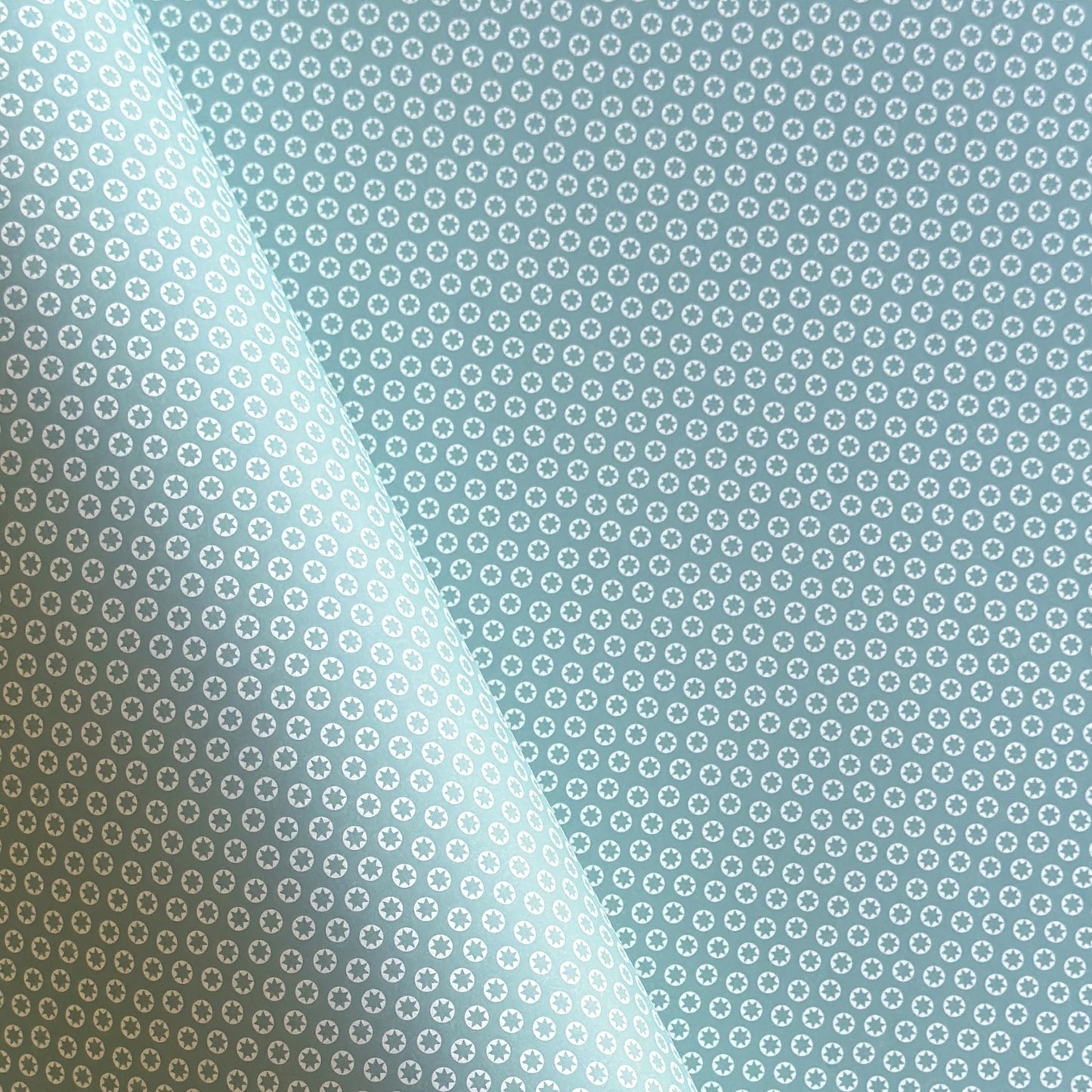 wrapping paper with an abstract tiny stars pattern in ice blue and white by Ola Studio